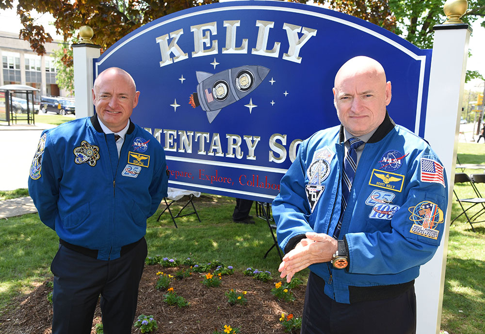 Retired twin astronauts, Scott (right) and Mark Kelly in front of the new sign to their New Jersey elementary school, which was renamed in their honor in May 2016. The brothers were subjects in NASA’s Twins Study. Credit NASA